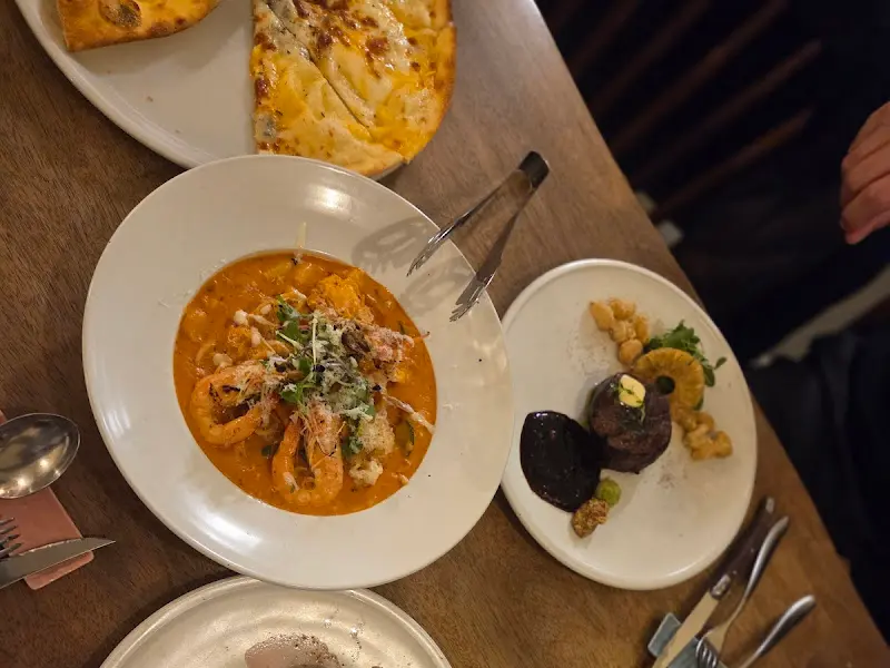 테이블 위에 놓인 파스타, 스테이크, 피자