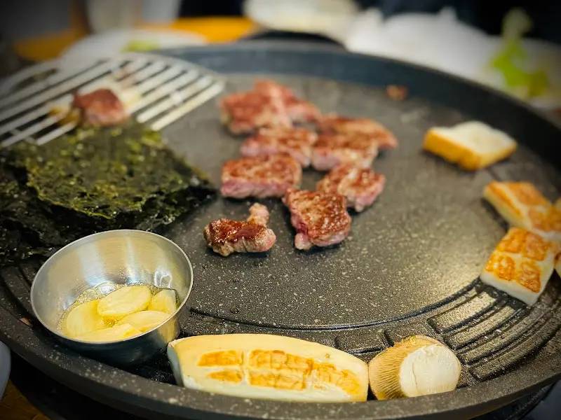 불판 위에서 익어가는 한우와 떡, 버섯