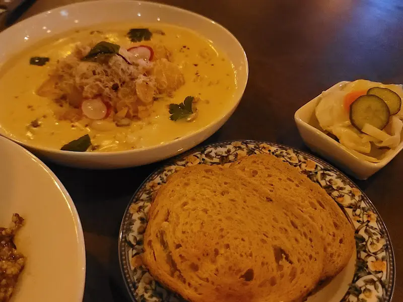 테이블 위에 놓인 크림 뇨끼, 빵, 피클