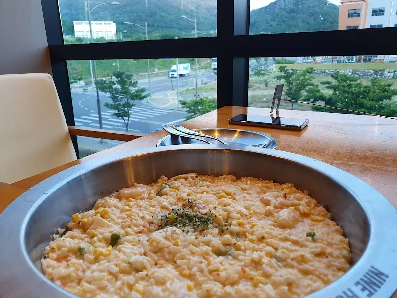 창밖 풍경이 보이는 테이블에 놓인 새우 리조또