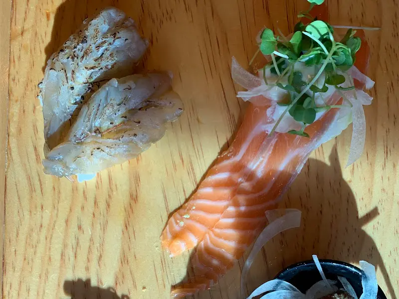 구운 초밥과 연어 초밥이 나무 도마 위에 놓여 있는 모습