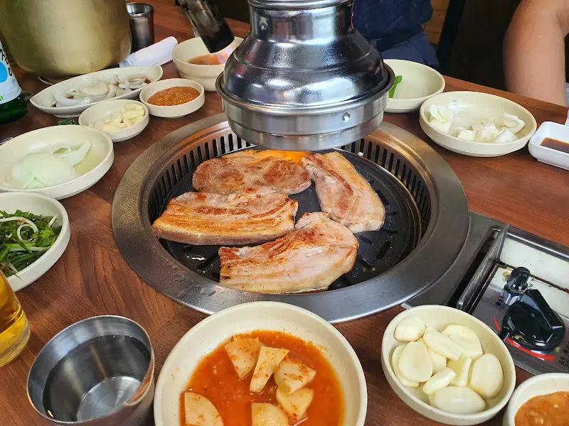 불판 위에서 구워지는 흑돼지 삼겹살