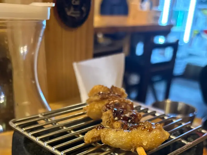 미니화로 위에 올려진 닭껍질 꼬치