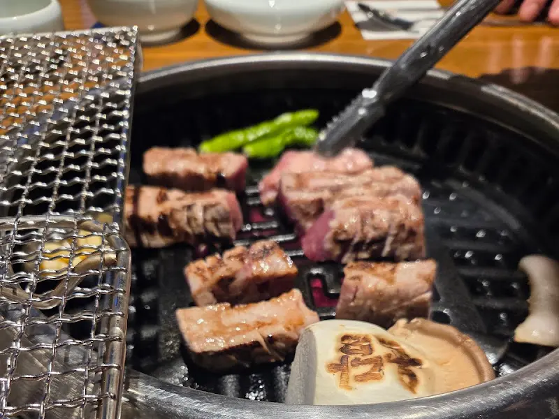 잘 익은 직각 목살을 집게로 들어 올리는 모습