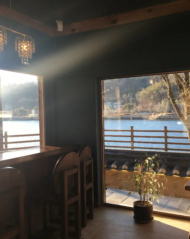 창밖으로 보이는 월영교를 바라보며 라떼를 마시는 모습