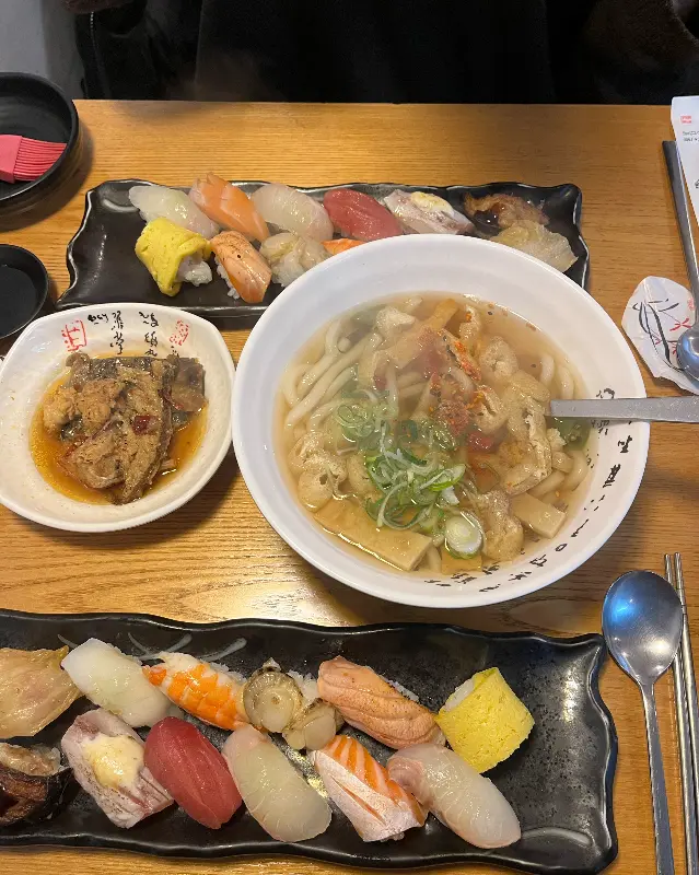 초밥과 우동, 생선조림이 함께 차려진 모습