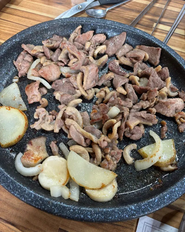 불판 위에 구워진 오리로스와 양파, 감자