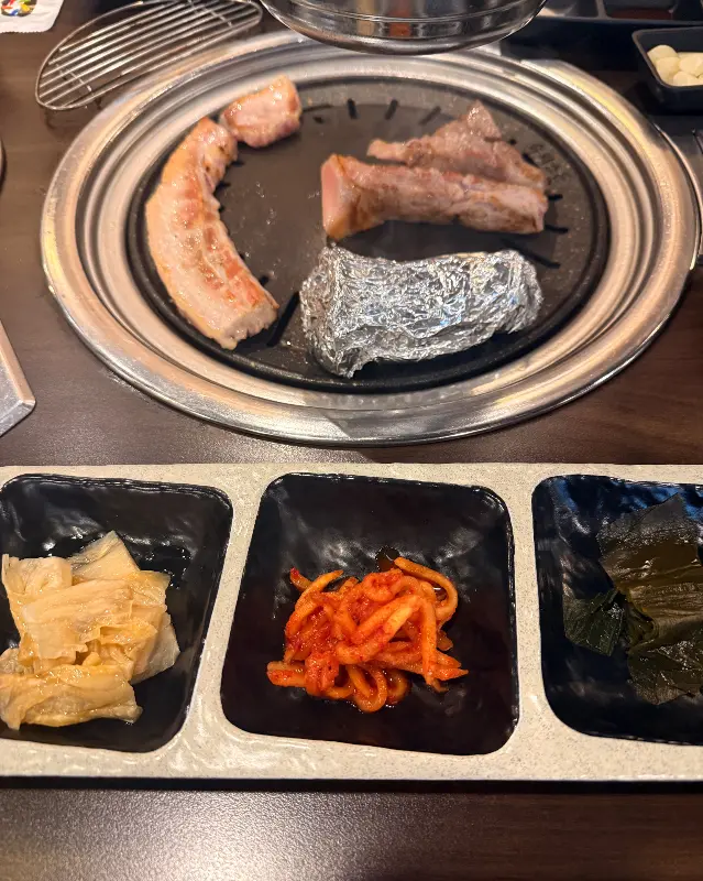 육풍 평택역점 불판 위에 구워지는 고기와 은박지에 감싸진 버섯 사진