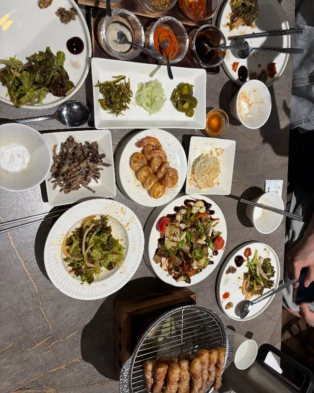 다양한 밑반찬과 소스가 테이블 위에 가득 차려져 있다.