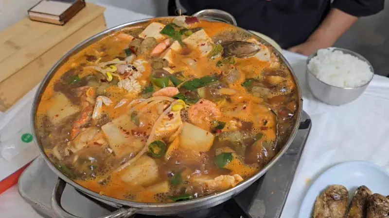 오징어볶음을 밥에 비벼 김에 싸 먹는 모습