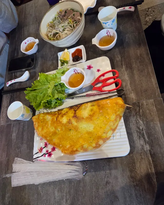 반쎄오와 쌀국수가 함께 놓여 있는 테이블의 모습