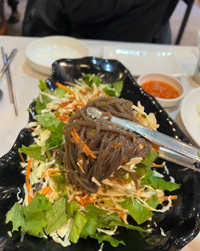 막국수를 들어올리는 모습