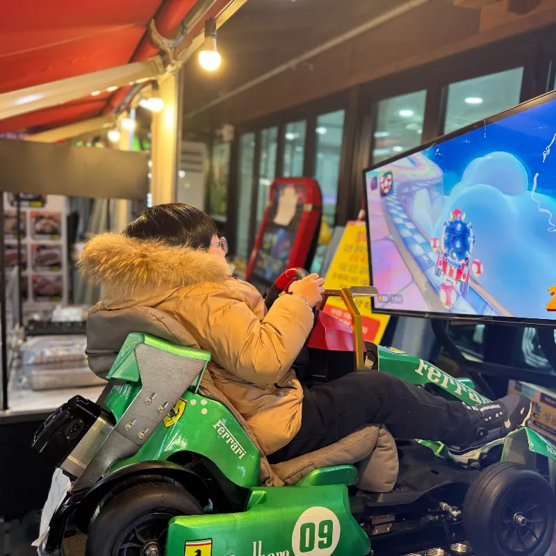 매장 앞에 놓인 오락기를 즐기는 아이