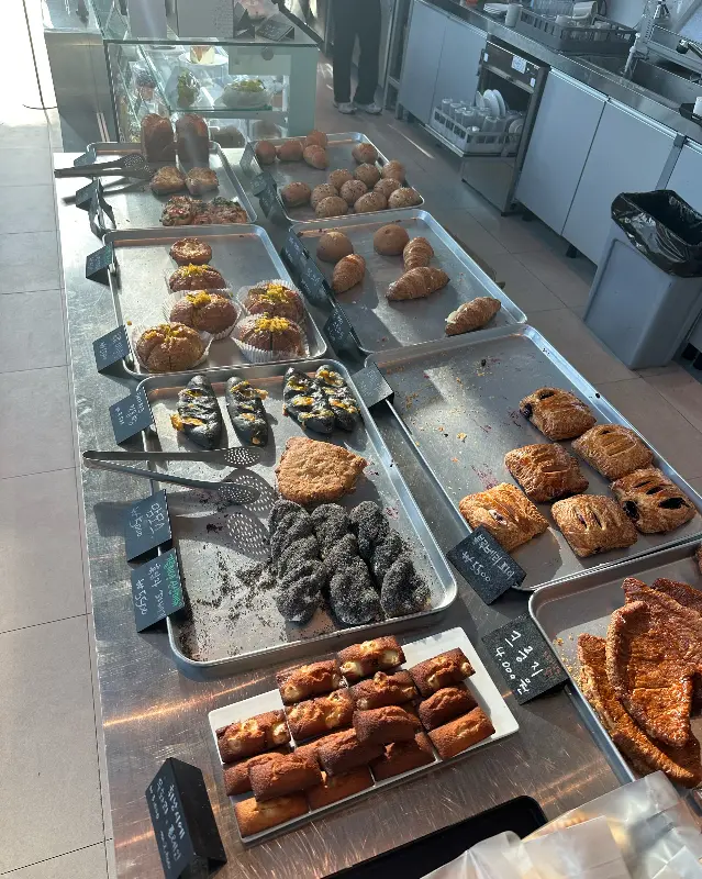 테이블 위에 놓인 빵과 음료. 다양한 종류의 빵이 먹음직스럽게 보인다.