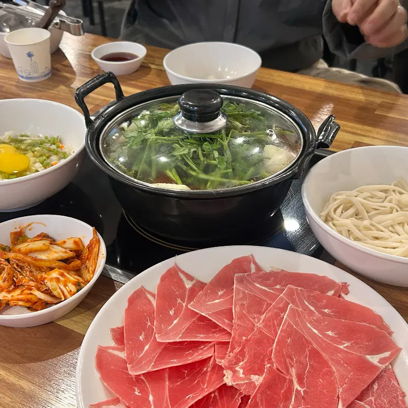 테이블 가득 차려진 샤브샤브 세트 메뉴