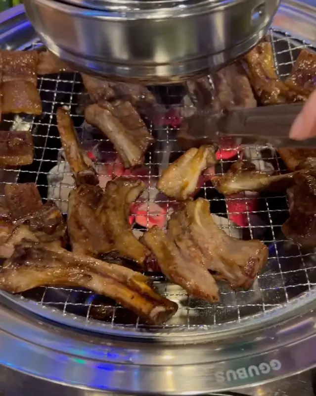 노릇하게 구워진 쪽쪽갈비를 집게로 들어 올리는 모습