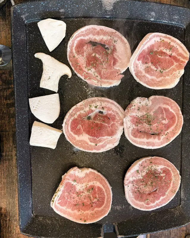 불판에 구워지는 삼겹살과 버섯