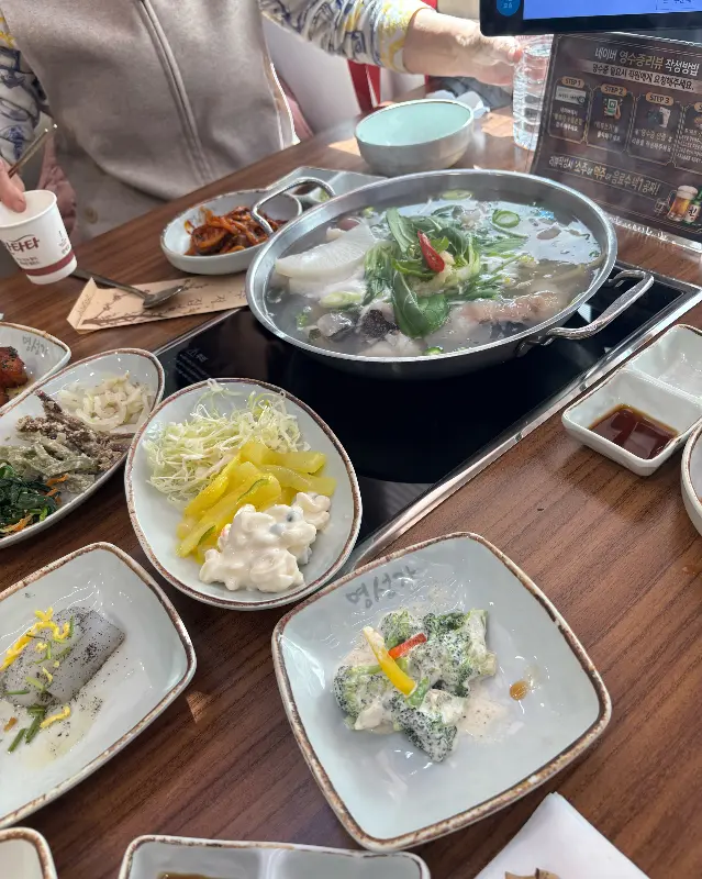 테이블 가득 차려진 다양한 밑반찬과 아구탕