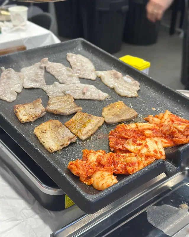 불판 위에서 익어가는 삼겹살과 김치