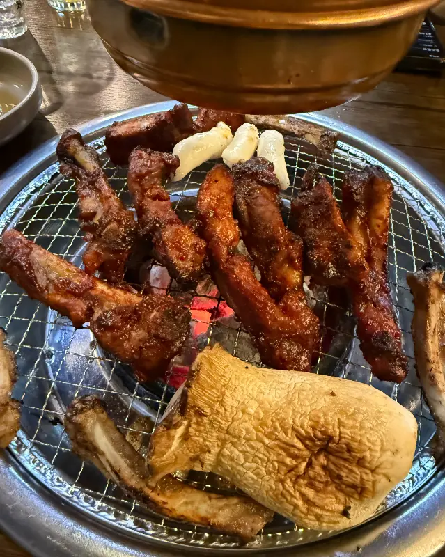 숯불 위에서 구워지는 쪽갈비와 떡