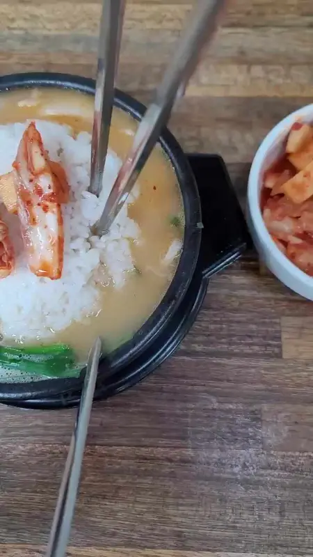 잘 익은 깍두기를 국밥 위에 얹어 먹는 모습