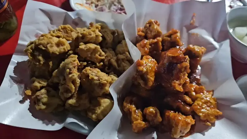 종이 위에 가지런히 놓인 후라이드 치킨과 간장 치킨