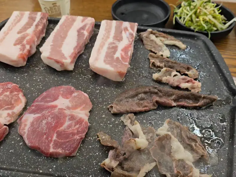 불판 위에 올려진 다양한 종류의 고기들