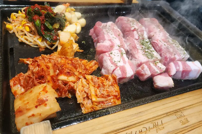 무쇠철판 위 삼겹살, 김치, 콩나물
