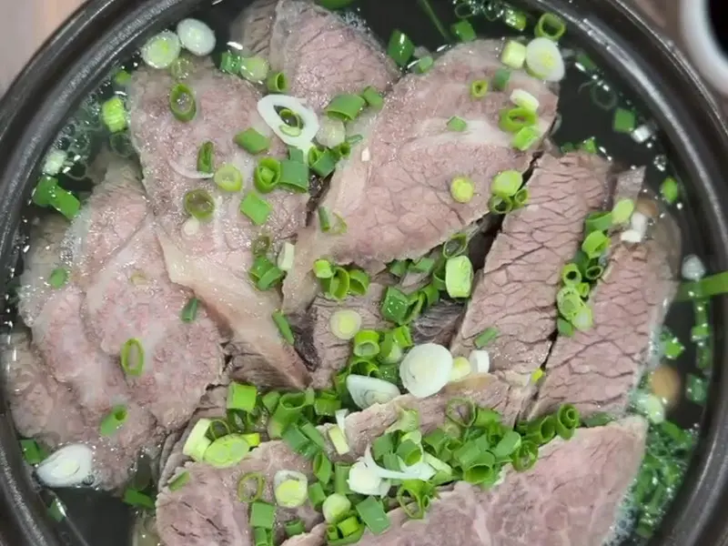 맑은 곰탕에 얇게 슬라이스된 고기가 듬뿍 담겨 있다.