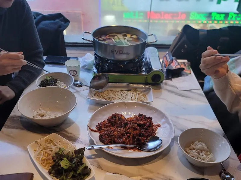 테이블 위에 놓인 쭈꾸미, 칼국수, 콩나물, 샐러드, 밥