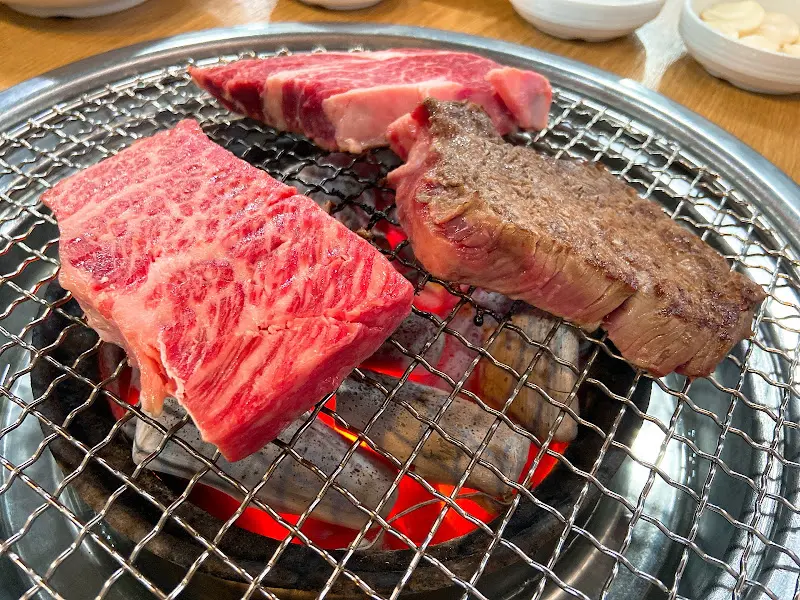 숯불 위에서 익어가는 한우 등심과 안심