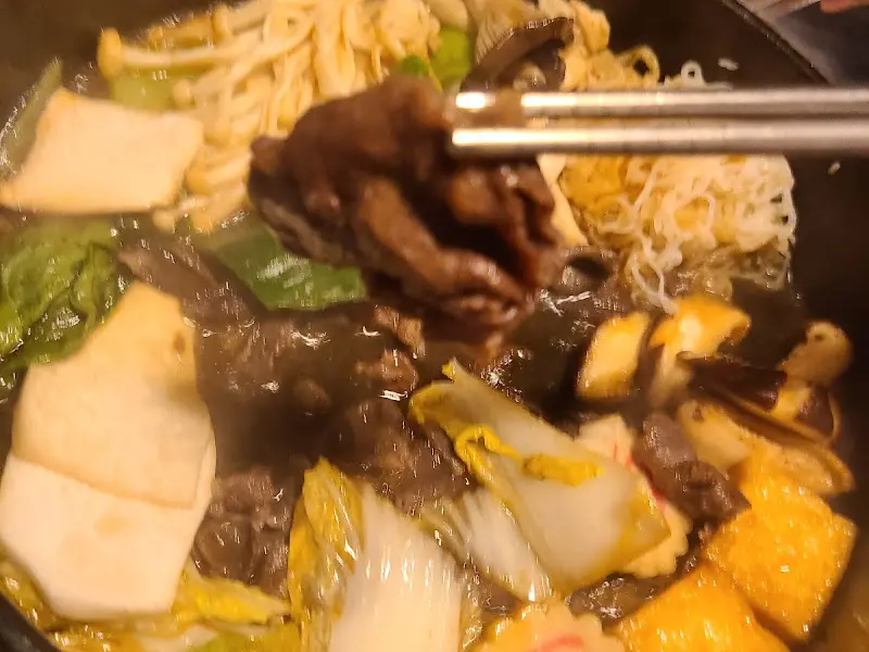 젓가락으로 스키야키 고기를 집어 올리는 모습