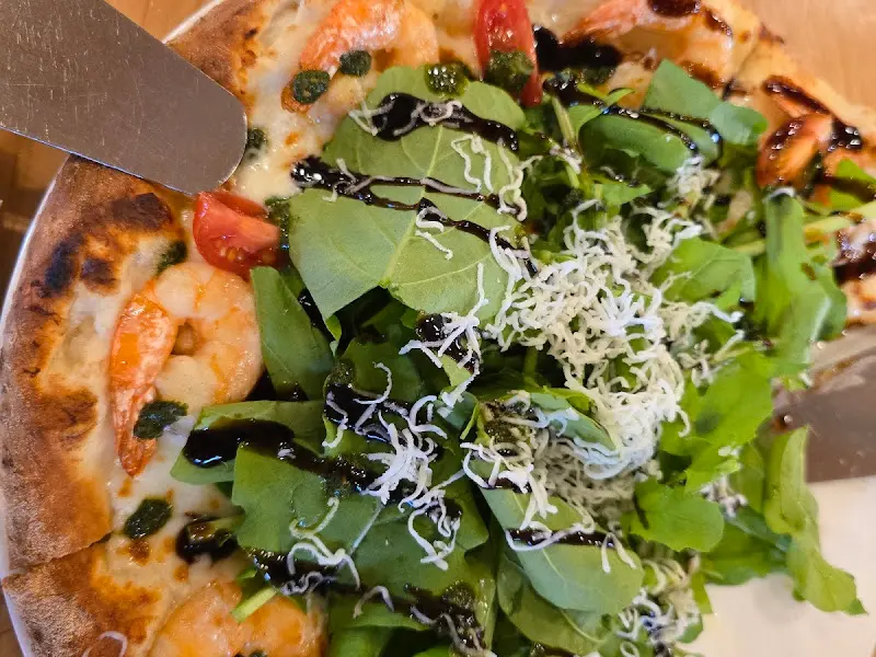 루꼴라 피자를 들어올리는 모습