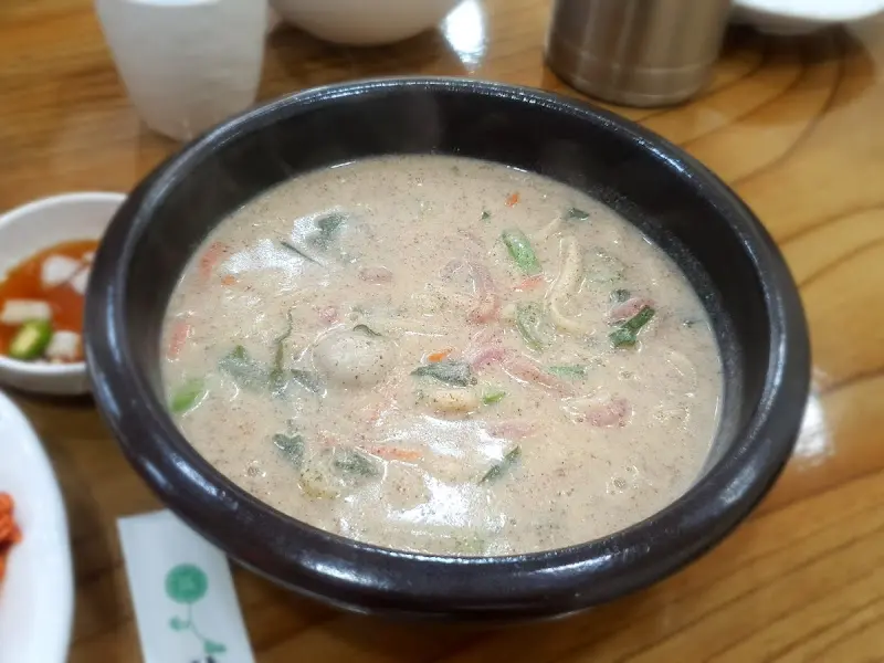 들깨 칼국수 한 그릇이 테이블 위에 놓여 있는 모습