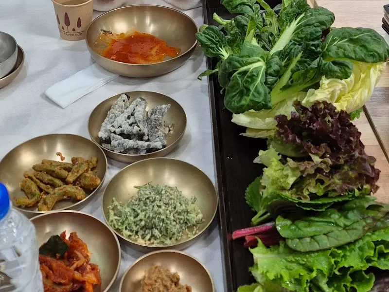 놋그릇에 담긴 다양한 반찬들과 쌈 채소