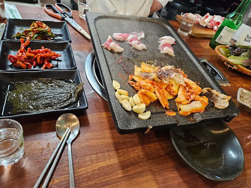 불판 위에서 익어가는 김치와 삼겹살