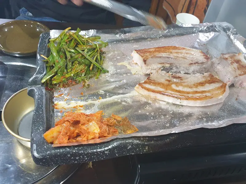 삼겹살, 김치, 부추를 함께 구워 먹는 모습