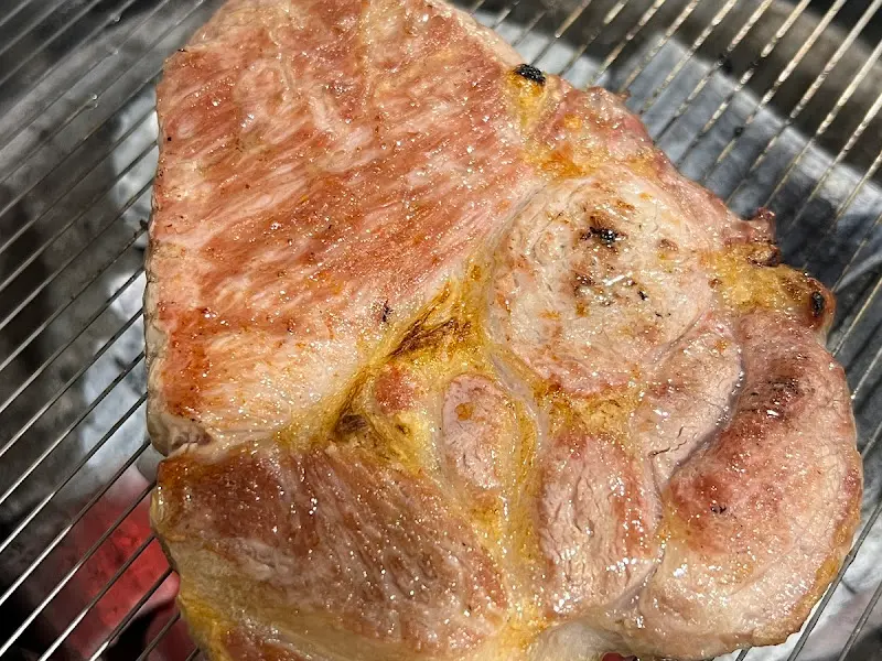 숯불 위에서 맛있게 구워지고 있는 두툼한 돼지고기