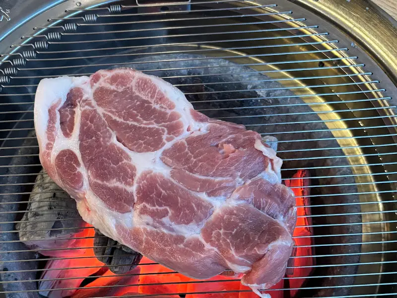 숯불 위에서 익어가는 통통한 돼지고기