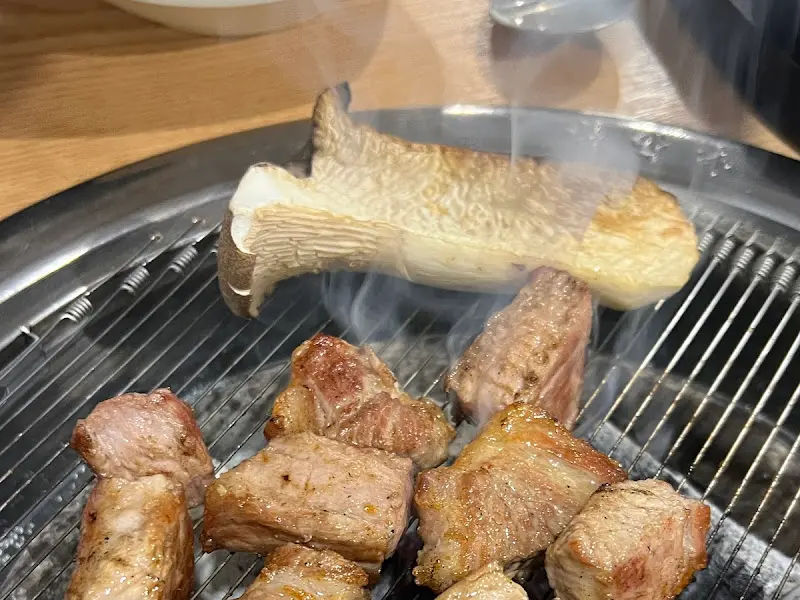 숯불 위에서 구워지고 있는 갈매기살과 버섯