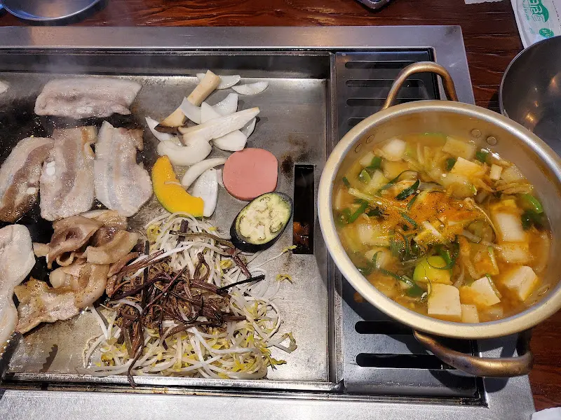 불판 위의 삼겹살과 곁들임 채소들