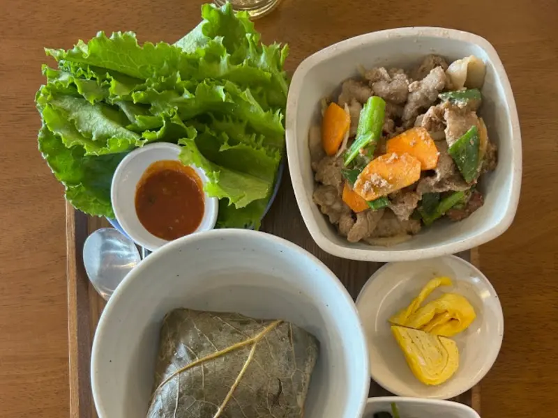 연잎밥 정식 한상차림: 정갈한 반찬과 윤기 흐르는 연잎밥이 식욕을 자극한다.