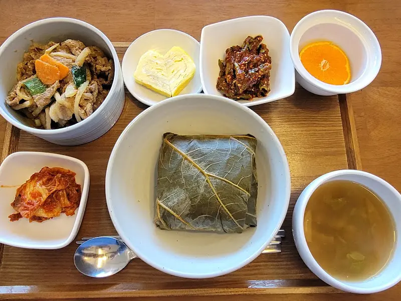 연잎밥 정식 클로즈업: 연잎에 싸인 밥과 다채로운 반찬들이 보기 좋다.