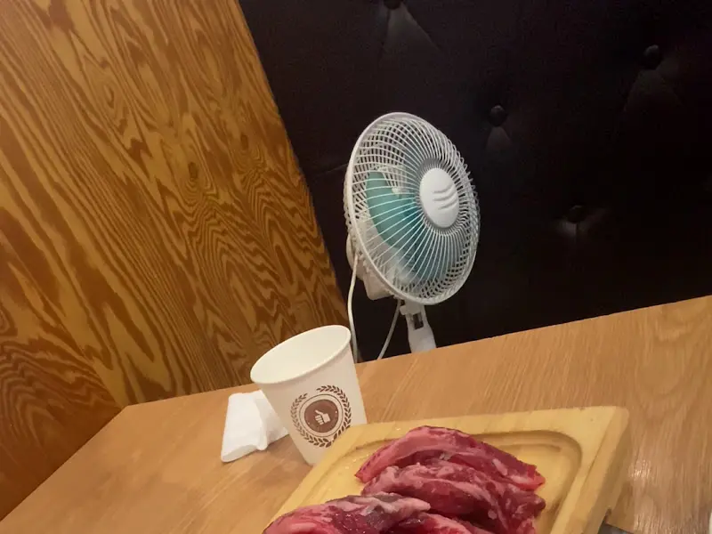 테이블 위에 놓인 컵과 미니 선풍기