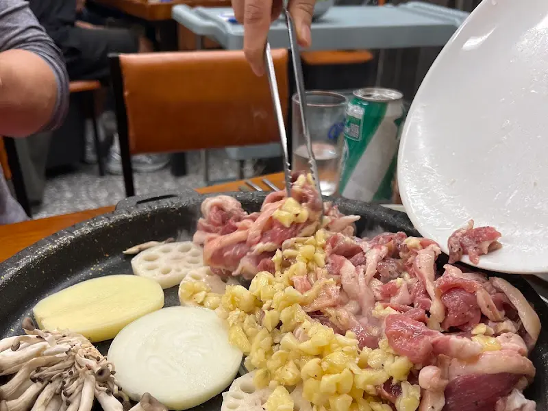 불판 위에서 익어가는 삼겹살과 미나리