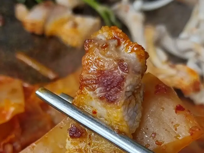 젓가락으로 집어 올린 삼겹살 한 점