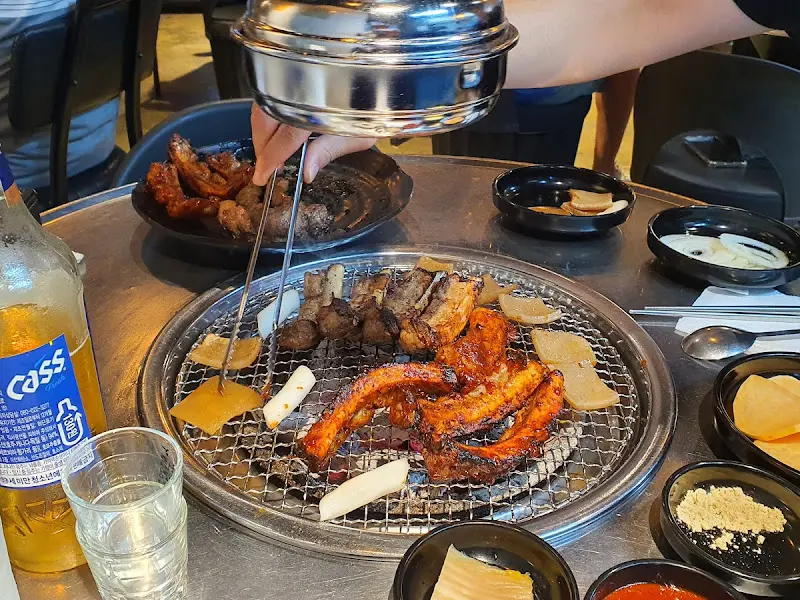 숯불 위에서 익어가는 쪽갈비와 떡, 마늘