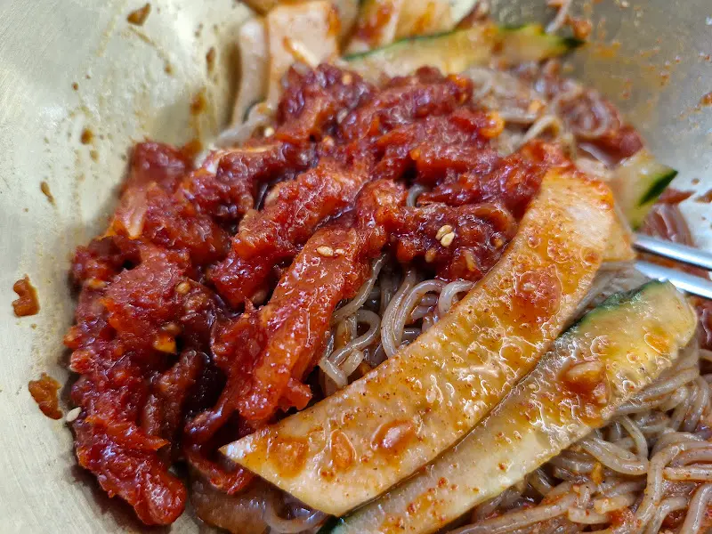 명태회무침이 올려진 비빔밀면의 모습. 붉은 색감이 식욕을 자극한다.