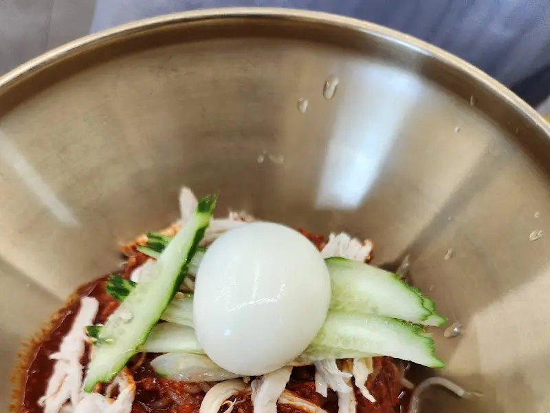 밀면 위에 올려진 삶은 계란과 오이 고명의 모습. 깔끔하고 정갈한 느낌을 준다.