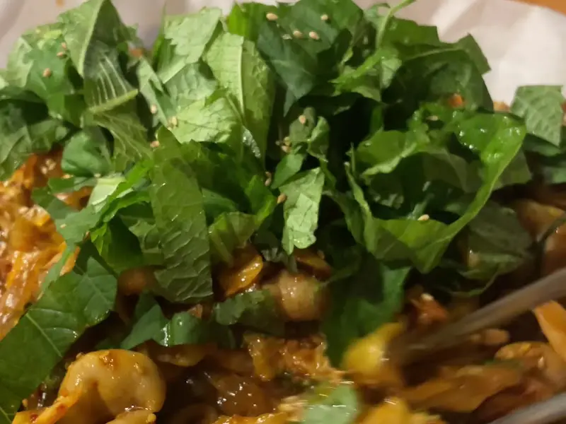 젓가락으로 깻잎과 대창을 집어 올린 모습